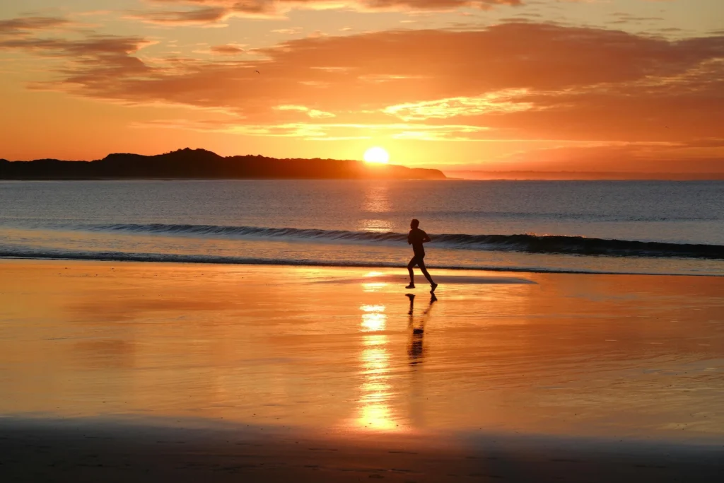 Homme exposé au soleil sur la plage, favorisant la production naturelle de vitamine D