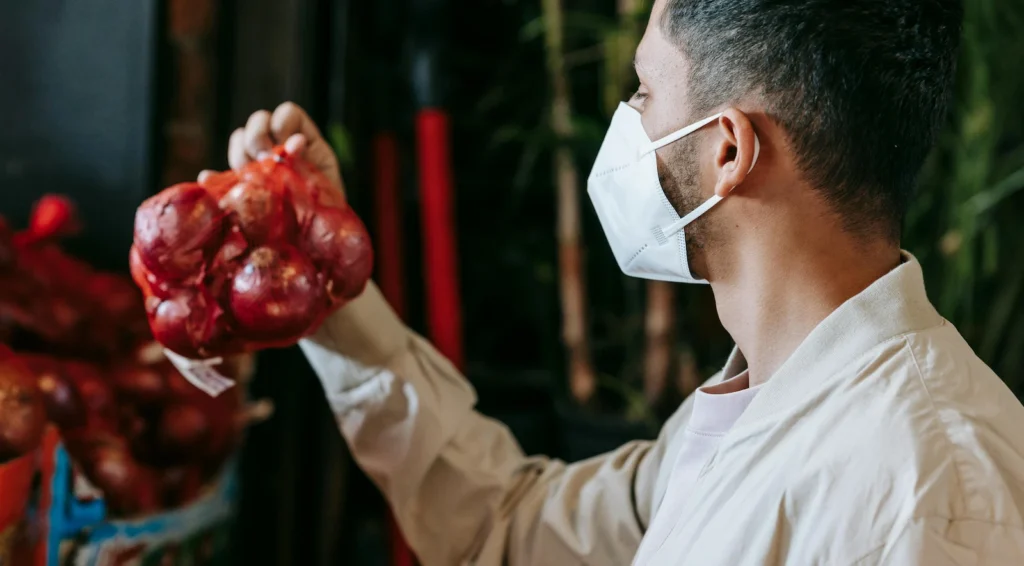Homme observant des oignons rouges riches en antioxydants pouvant influencer la testostérone et les hormones