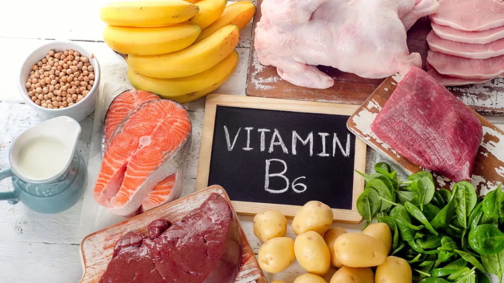 Aliments sources de vitamine B6 autour d’une ardoise « Vitamin B6 », pour illustrer son lien avec la prolactine et la testostérone.