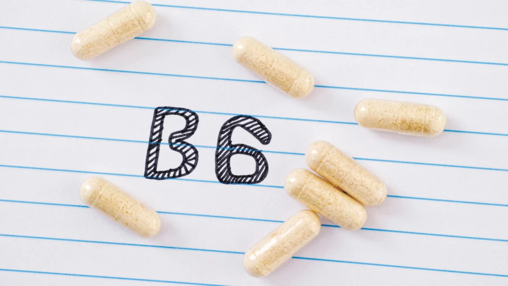 Les compléments de vitamine B6 nécessitent de surveiller les doses Gélules disposées sur une feuille portant l’inscription « B6 », illustrant la supplémentation en vitamine B6.