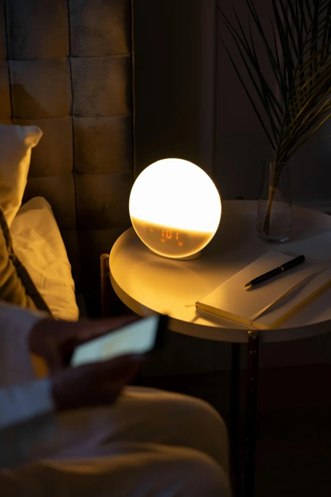 Lampe de réveil lumineuse dans une chambre sombre, illustrant le lien entre rythme circadien, qualité du sommeil et récupération hormonale